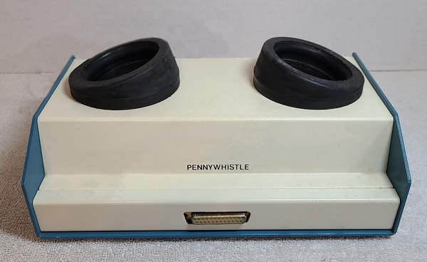 A photoshopped version of the 1970's era Pennywhistle 103 "acoustic compiler" modem from this post: https://hachyderm.io/deck/@thomasfuchs/111897606792710926 with the switches removed to make it look more like a face