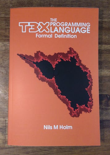 A copy of the book "The T3X Programming Language - Formal Definition" with a Mandelbrot set as its cover art