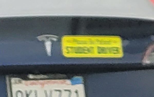 Tesla with bumper sticker "Please Be Patient: Student Driver"