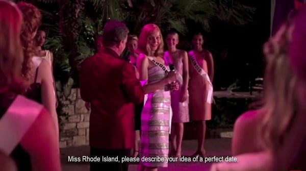 A young woman pageant contestant in a ballgown standing next to the announcer, an older man wearing a suit. “Miss Rhode Island, please describe your idea of a perfect date.”