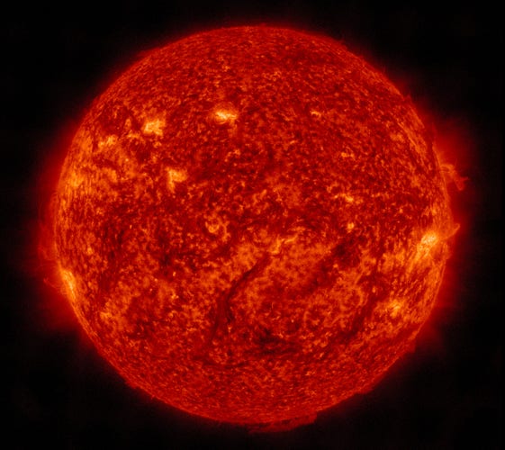 Die ganze erdzugewandte Seite der Sonne in orangeroter Farbe. An einigen Stellen etwas hellere Regionen und am Rand hier und da ein leichter Saum aus Strahlung.
