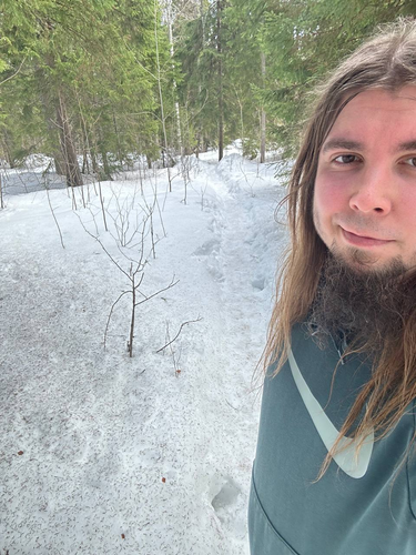 Me smiling in the snowy forest.