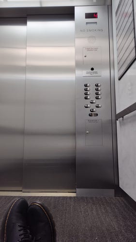 The interior of an elevator is shown stuck in the fourth floor.