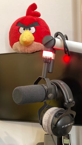 Ein Mikrofon an einem Arm mit einem Kopfhörer drangehängt.