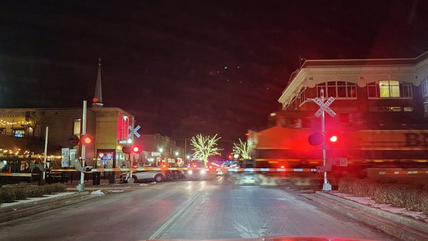 A blurred bnsf train engine enters an intersection at night.