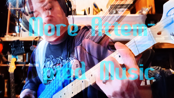 Superimposed images of middle aged man in headphones holding a guitar and singing, and same man (me, duh) holding a bass and not singing, behind the words "More Attem-pted Music". It's all blended, so the letters are kinda blue-green, but parts of the other bits show through.
