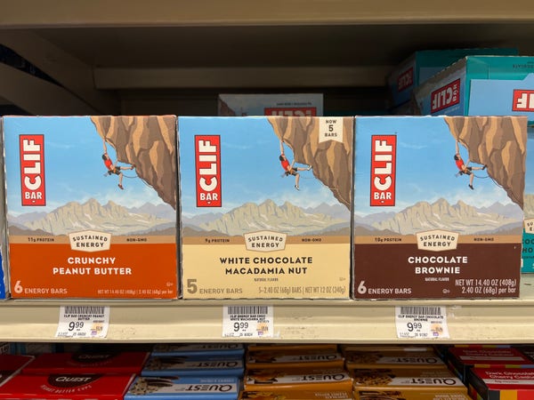 Three Cliff energy bar packs. Two flavors contain six bars, the one in the center only has five. The price is the same for all of them. The middle liable incorrectly states the price per ounce as the same as the other two.