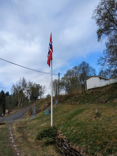 Et norsk flagg som henger i ei flaggstang 