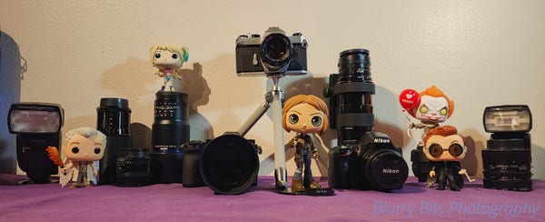 A collection of camera gear with a few funko pop characters amongst them.