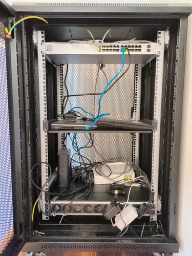 Front view of sparsely populated server cabinet with very disorganized cabling.