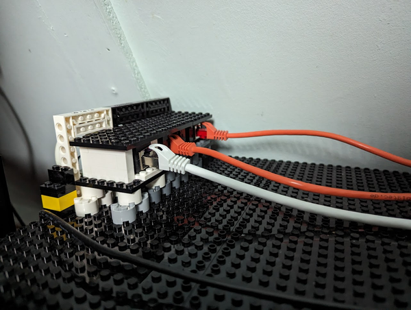 Internal side of the left patch box showing elevated RJ45 patch blocks in their lego housing connected with cables.