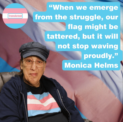 (Accessibility: “When we emerge from the struggle, our flag might be tattered, but it will not stop waving proudly.” Monica Helms Photo: Monica Helms, a woman with long hair wearing a cap and glasses. In the background of the image is a big trans flag)