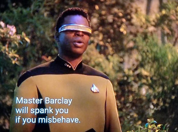 TNG scene. We're outside in a forest, and looking up at LaForge in uniform and trademark eye visor. Also, he kind of looks like he's whistling. Closed caption reads, "Master Barclay will spank you if you misbehave."