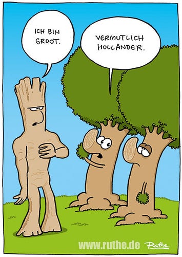 Auf einer Wiese. Dort steht Groot, zeigt auf sich und sagt "Ich bin Groot.". Neben ihm stehen zwei Ruthe-Bäume. Linker Baum zum rechten Baum: "Vermutlich Holländer."