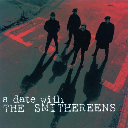 The cover of 1994 album A Date with The Smithereens. The band is standing out in the street near a crosswalk, shot from above in a dark, foreboding kind of shot. The typewriter type text of the album's title is on the bottom of the cover in white.