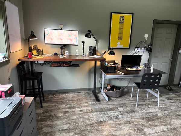 I work from these two desks — mostly the standing one but sometimes the sitting one. (Bonus Sammy Genehack photo bomb!)