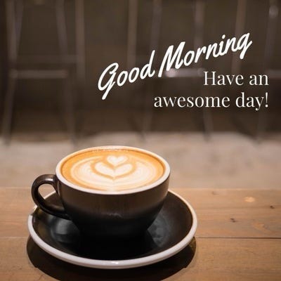 A cup of coffee with heart-shaped latte art on a wooden table with the text "Good Morning - Have an awesome day!" above it.