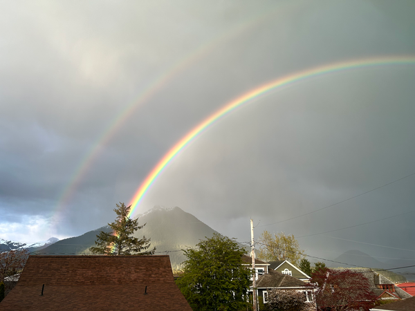 double rainbow over mountains and homes