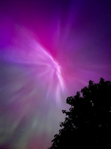 Purple red and green aurora that looks like the sky is ripping.  Photo credit to a family member who got the best shot.