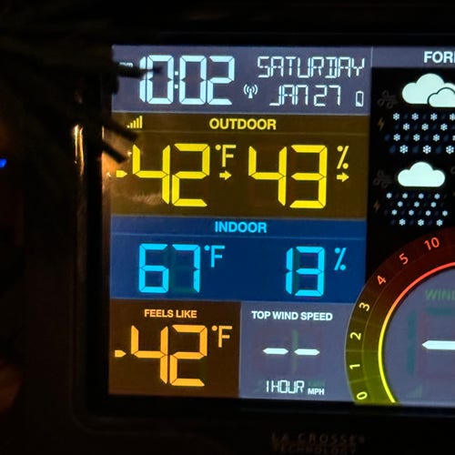 A photo of a colorful home weather station display. It reads:
10:02pm Saturday Jan 27
Outdoor -42°F / 43% humidity
Indoor 67°F / 13% humidity
The “Feels Like” temp is also -42, and the wind speed reading is blank, because we don’t have the anemometer hooked up yet.