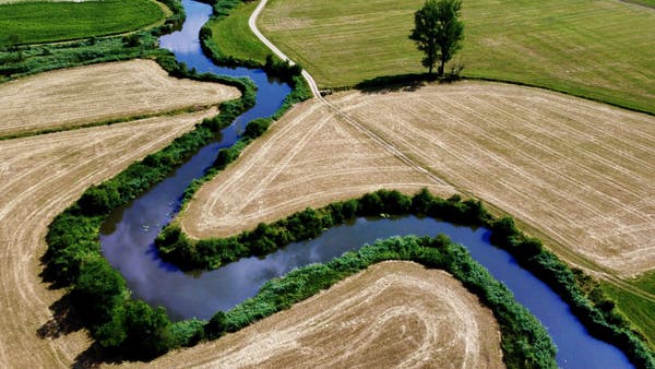 Aerial view of meandering Woernitz river surrounded by agricultural fields.