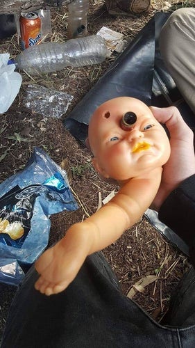 weird pipe made out of parts of a baby doll and the bowl is stuck into the forehead