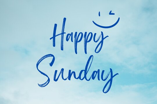 An image with a background of clouds and the words Happy Sunday in a blue font. There is a smiley face as well at the top.