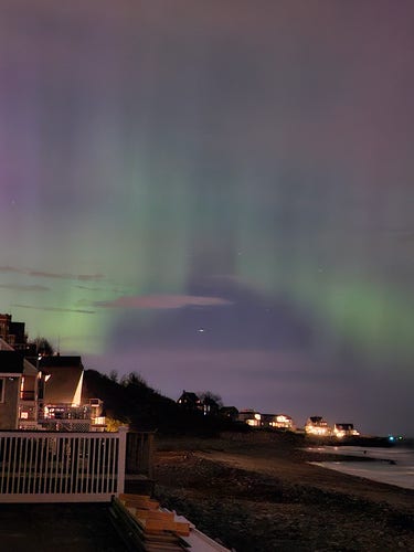 Cell phone picture of the arora borealis over a beach side town. 