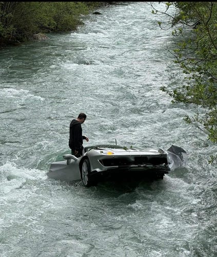 Expensive car (edit Ferrari 488 pista) in river with driver getting out of it. He looks safe
