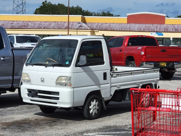 Honda Acty kei truck in a parking lot.