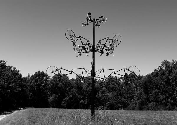 Sculpture de vélos qui représente un arbre. Elle est au milieu d'un pré. Cette photo date du 7 juillet 2020 et est prise dans le Tarn et Garonne 