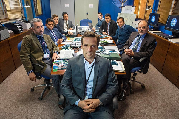 pomieszczenie biurowe w którym siedzi 9 oficerów wywiadu DGSE przy stole konferencyjnym - zdjęcie reklamujące serial