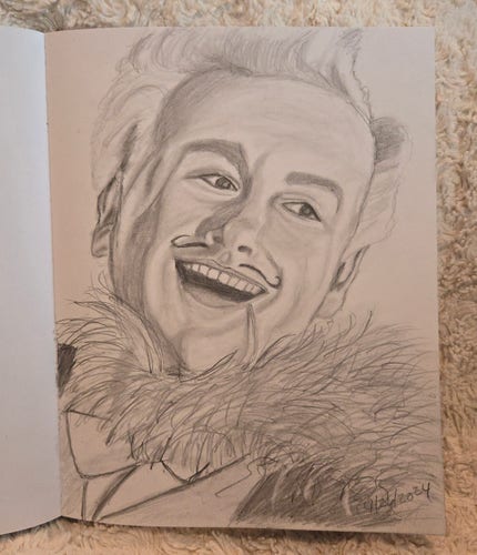 A sketchbook is open to a pencil sketch of Michael Sheen as Aziraphale in Good Omens, dressed as his magician personality, Fell the Marvelous. He has a wide smile on his face, his blond curls are brushed in a 1940s style, and he has a feather boa around his neck, looking very triumphant after a successful magic act.