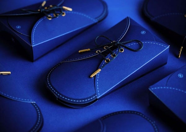 A photo showing a blue product package designed to look like a shoe, complete with shoelaces that have to be untied to reveal the socks nestled inside.