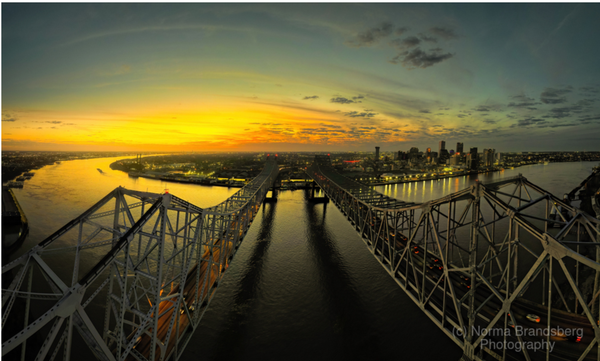 New Orleans over the Mississippi River cityscape at sunset  more here:

https://www.pictorem.com/879938/New%20Orleans%20Mississippi%20River%20Front%20Bridges%20Panorama.html