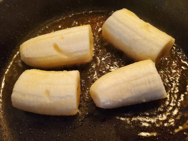 4 pieces of banana in frying pan, with coconut oil.