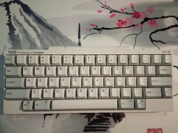 Picture of a retro looking keyboard on a mousepad showing japanese style art.