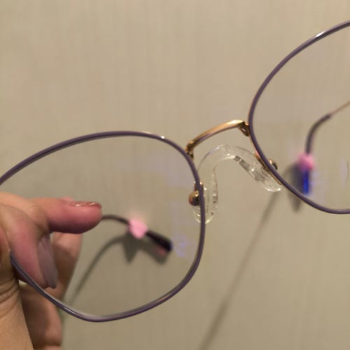Pair of glasses with a silicone nose pad that bridges across the nose instead of sitting on either side