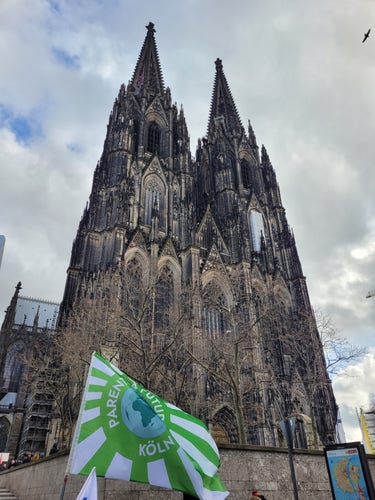 Kölner Dom, im Vordergrund eine Fahne der Parents for Future.