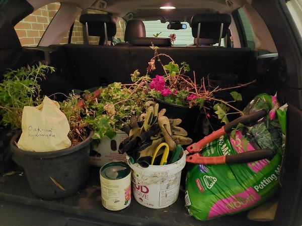Car boot with lots of pots, potting soil and gardening equipment