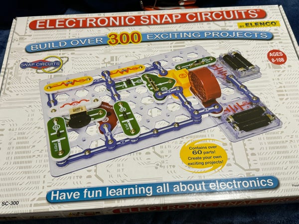 Box of Electronic Snap Circuits by Elenco, a kit for building over 300 electronic projects, suitable for ages 8-108. The illustrated cover shows various circuit components and promises a fun learning experience about electronics.