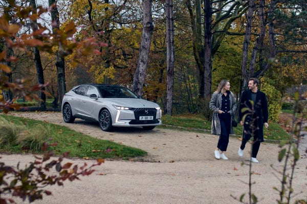 Una delle foto di presentazione di DS3 e DS4 in cui un'auto è parcheggiata nel vialetto di un parco con due persone che passeggiano vicino, forse i proprietari dell'auto