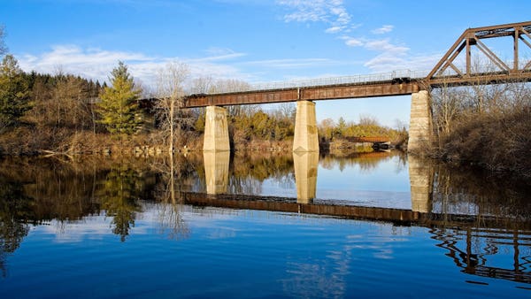Early spring shot of an old rail bridge over blue water.