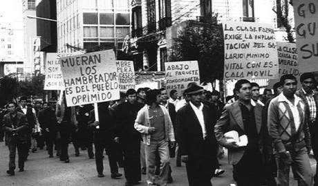 Bolivians marching through the street with picket signs during the 1985 General Strike.