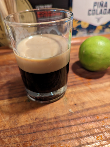 It appears to be a miniature pint glass of Guinness (dark brown below, a "head" on top) but is actually Kahlua and Bailey's