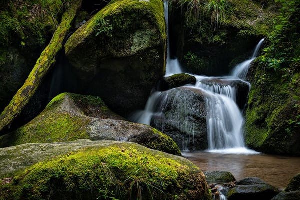 Ein Bild eines Wasserfalls mit bemoosten Steinen