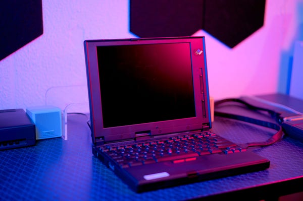IBM ThinkPad 560. It's a 13", relatively thin (for the 1996 vintage) machine with no internal CD-ROM nor floppy drive. The battery pack is placed in the front of the machine, under the palmrest. Brightness and contrast slider controls are present to the right of the LCD panel.