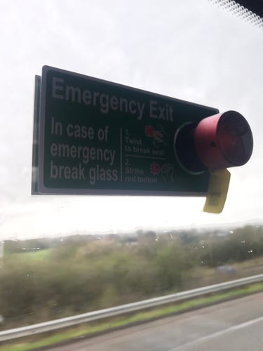 Big red button on window, with sign which reads ‘in case of emergency, break glass - twist to break seal, strike red button’