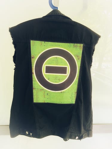 Eine schwarze Jeansweste mit einem großen Type O Negative Backaptch, das das Bandlogo auf grünem Grund zeigt