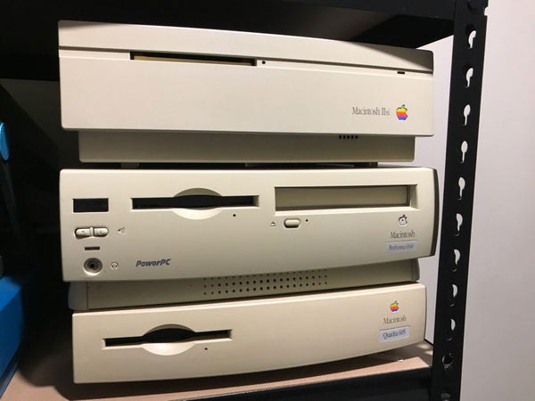 A photo of three Apple macs on a shelf, beige models from the 1990s - a Macintosh IIsi on top, a Performa 6360 in the middle, all being supported by the bottom-most Quadra 605.